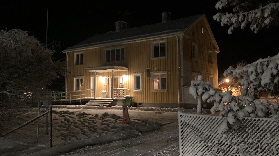 Gult trähus i två våningar i vinterskrud.