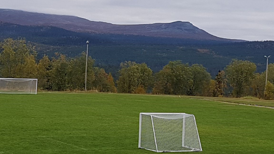 Fotbollsplan med fjäll i bakgrunden 