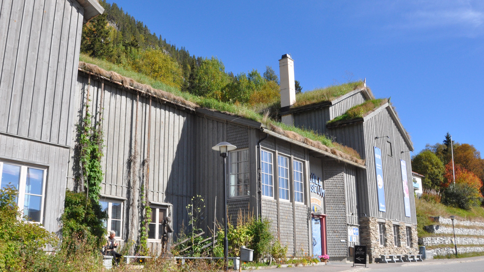 Grå träbyggnad med torvtak.