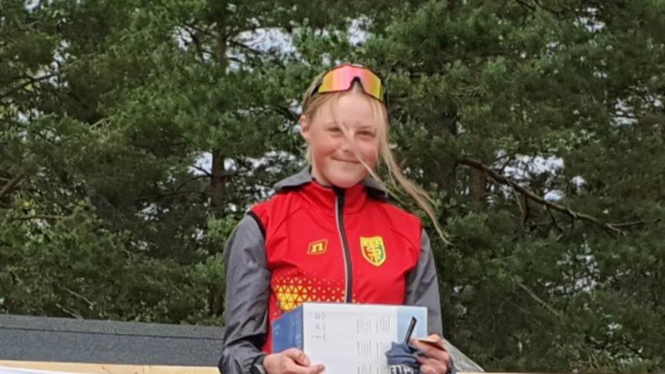 Flicka som står på en prispall.
