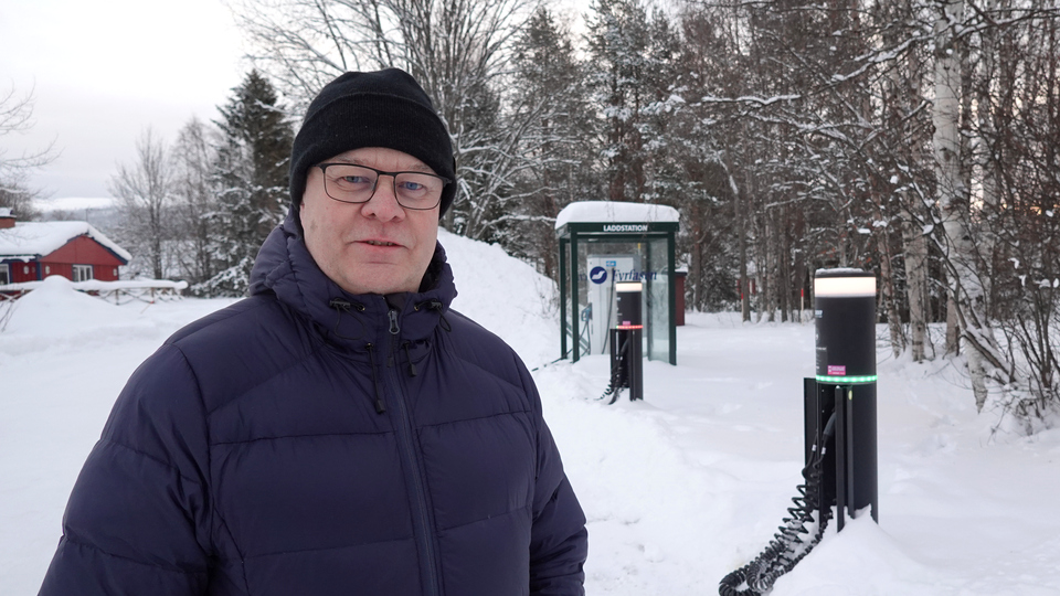 En man med toppluva i snötäckt landskap.