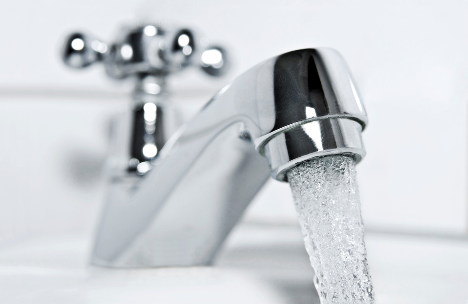 drinking water flows from a chrome water tap.