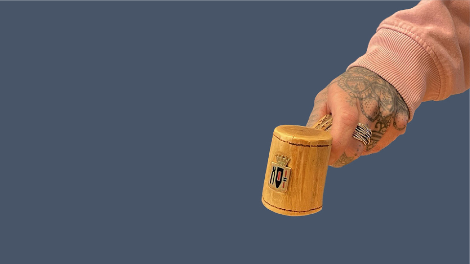 En tatuerad hand som håller i en ordförandeklubba