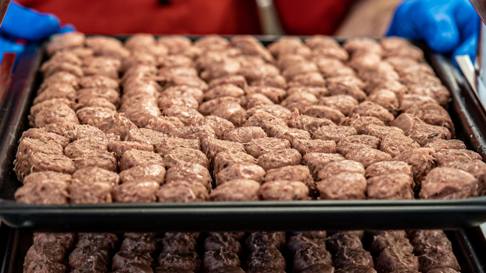 Massor av köttbullar på en ugnsplåt.