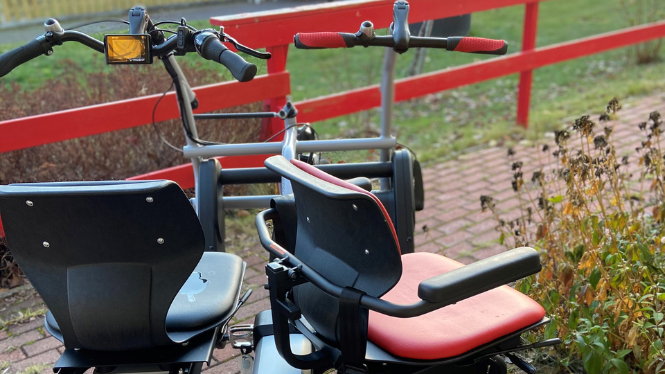 Cykel för två personer som sitter bredvid varandra med varsitt styre.
