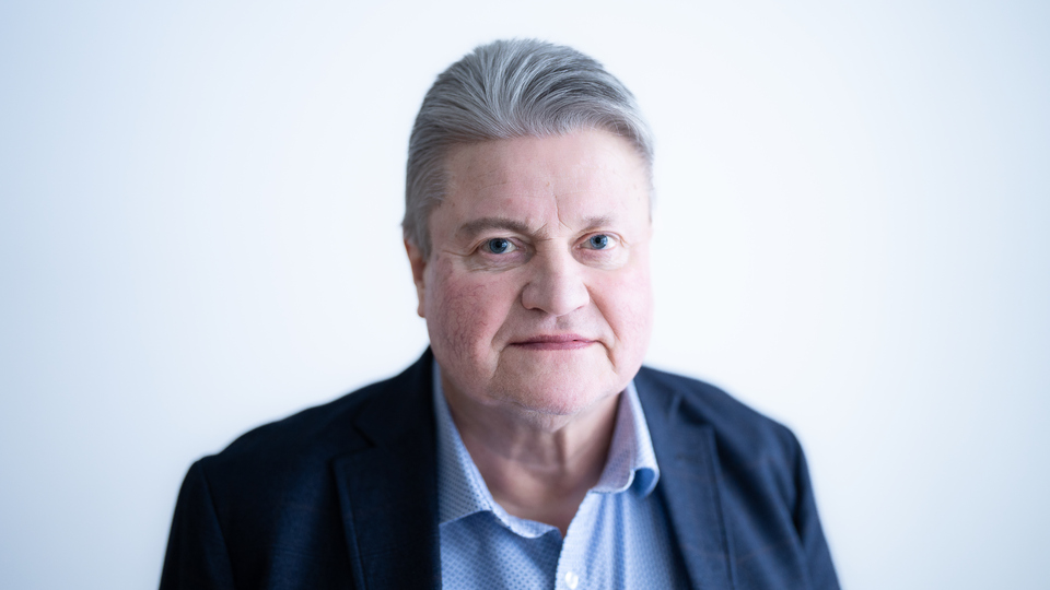 En man med kavaj och blå skjorta