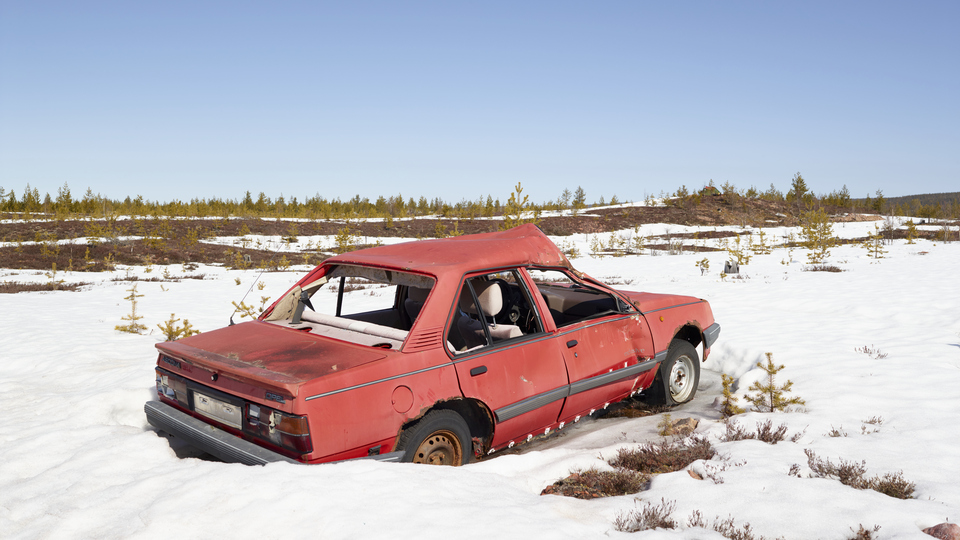 En skrotbil som står i snön.