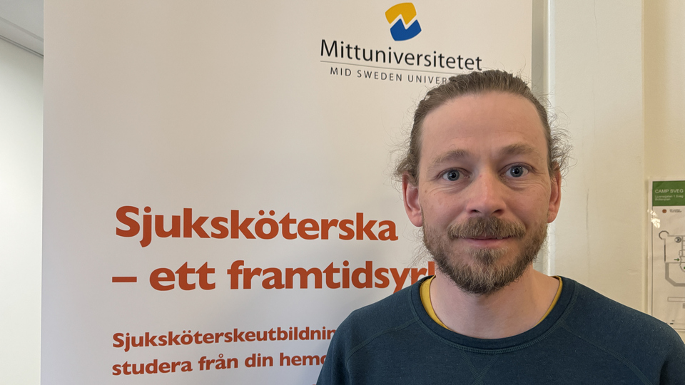 En man som står framför en skylt.