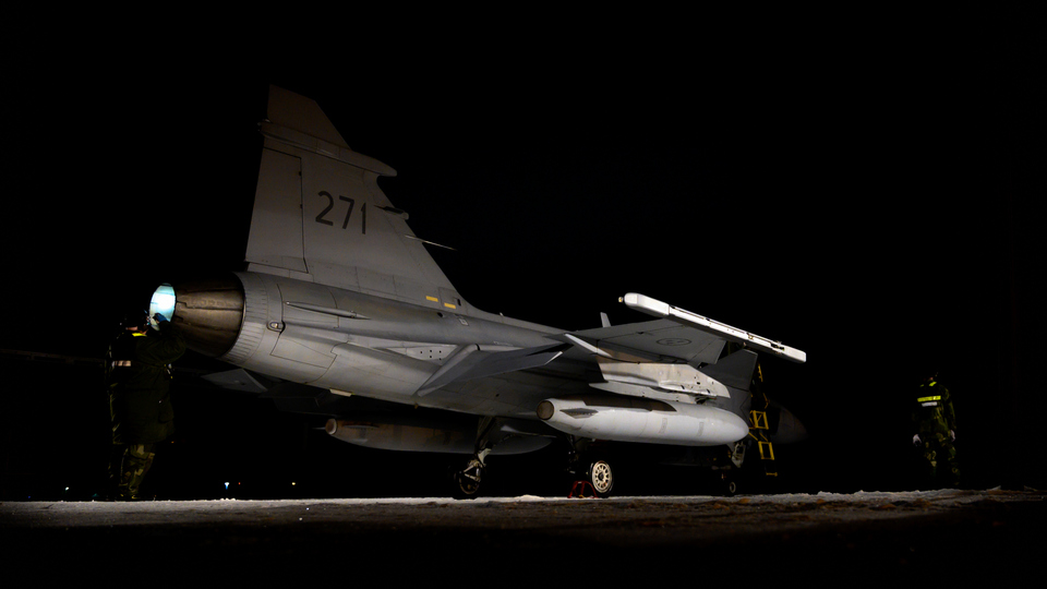 Jas 39 Gripen på rullbana i mörker.