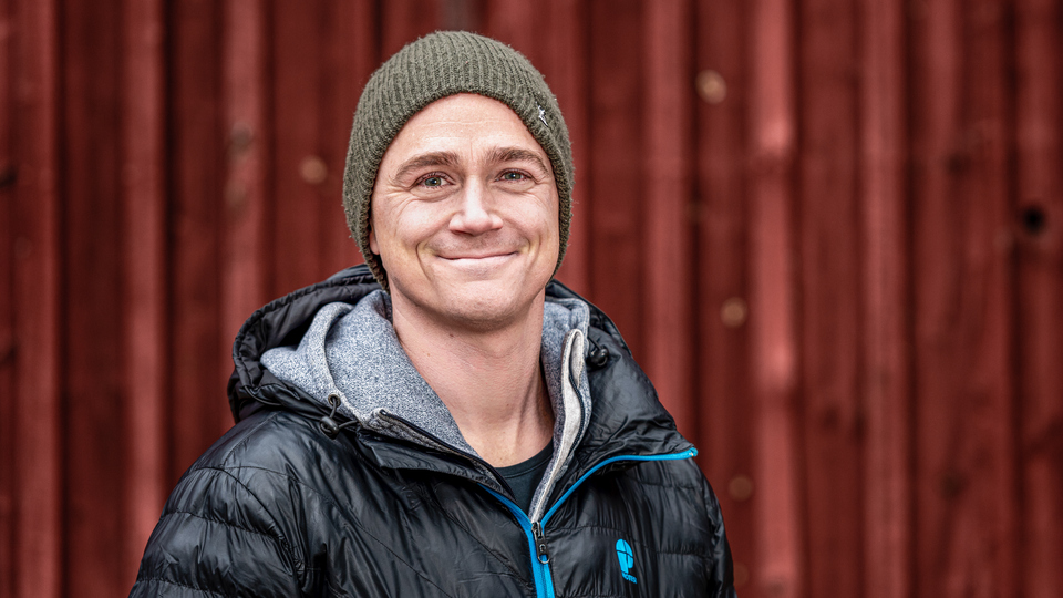 En man i svart jacka och grön mössa