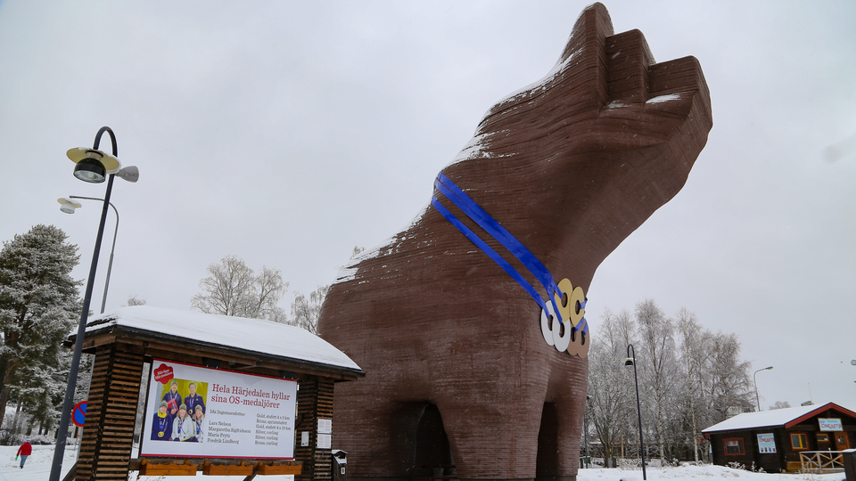 Stor björn i trä med medaljer runt halsen.