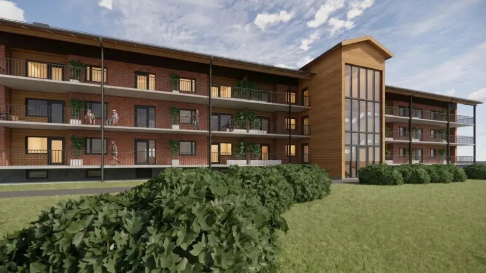 Arkitektskiss av byggnad i gräsbevuxet område.