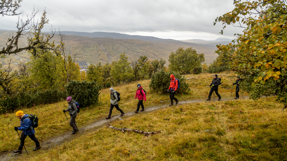 Människor som vandrar i fjällen en regnig höstdag.
