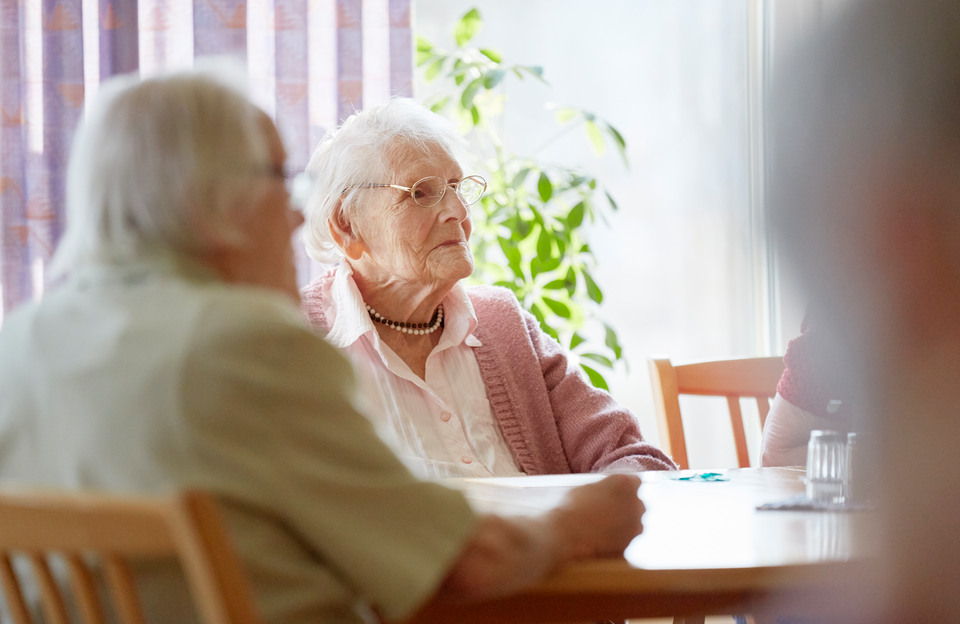 Äldre kvinna (100 år) i uppehållsrum på äldreboende