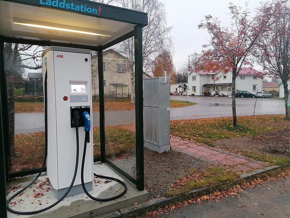 Kur med snabbladdare för elbilar vid en väg.